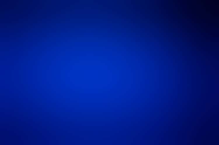 An expanse of what looks like deep-blue sand lit from above, glistening, its outer edges blanketed in darkness.